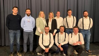 News Gruppe von zehn Personen in legerer und formeller Kleidung vor einem Vorhang