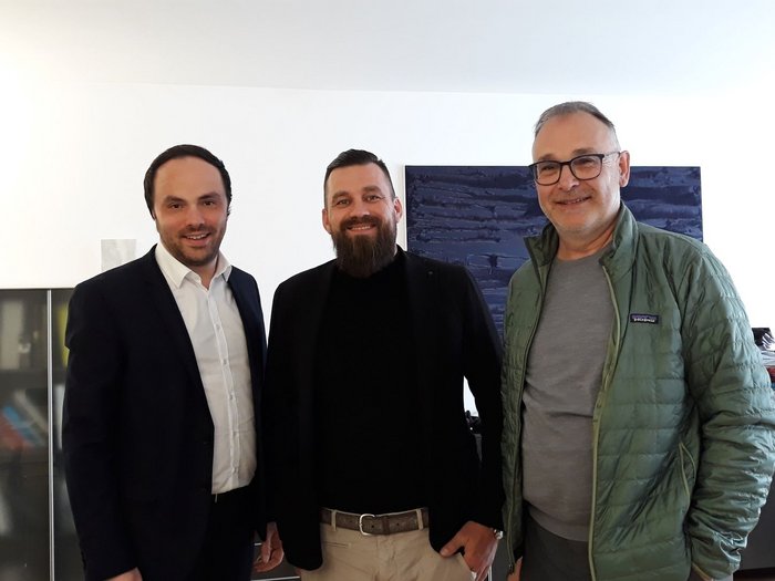 Wichtiges Treffen der Metzger/innen mit Landesrat Achammer Drei Männer stehen zusammen in einem Raum und lächeln in die Kamera