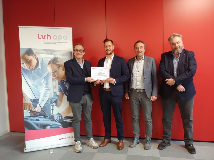 lvh vergibt erneut Stipendium Vier Männer stehen vor einem roten Hintergrund und halten eine Urkunde