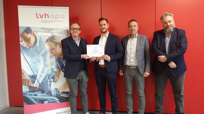 lvh vergibt erneut Stipendium Vier Männer stehen vor einem roten Hintergrund und halten eine Urkunde
