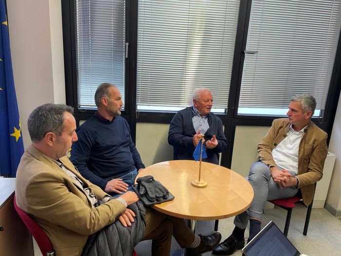 Antrittsbesuch bei dem EU-Abgeordneten Herbert Dorfmann Vier Männer sitzen um einen runden Tisch und führen ein Gespräch im Büro