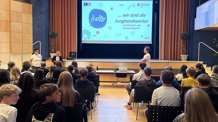 In die Welt der praktischen Berufe eintauchen Jugendliche besuchen eine Präsentation der Junghandwerker auf einer Bühne in einem Saal