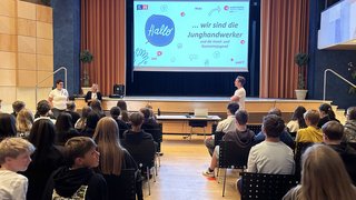 News Jugendliche besuchen eine Präsentation der Junghandwerker auf einer Bühne in einem Saal