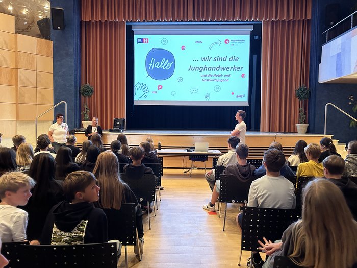In die Welt der praktischen Berufe eintauchen Jugendliche besuchen eine Präsentation der Junghandwerker auf einer Bühne in einem Saal