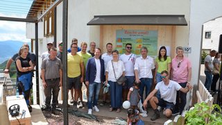 © lvh.apa Gruppenfoto von Menschen vor einem Gebäude mit einem Informationsschild