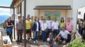© lvh.apa Gruppenfoto von Menschen vor einem Gebäude mit einem Informationsschild