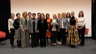 News Gruppe von Frauen steht auf Bühne vor weißem Hintergrund