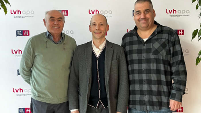 Praxisnahe Lösungen für das Elektronische Fahrtenblatt gefordert Drei Männer vor einer LVH APA Werbewand, zwei lächelnd und einer neutral