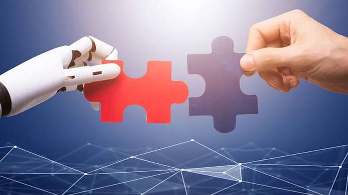Digitalisierung: Der Mensch im Mittelpunkt Roboter- und menschliche Hand verbinden Puzzleteile vor digitalem Netz