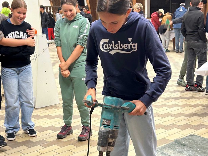 JHW-Wipptal Mädchen bedient Betonmischer, andere beobachten beim handwerklichen Workshop