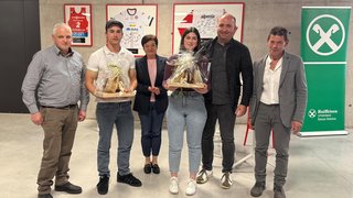 News Sechs Personen posieren mit Geschenken vor Sporttrikots und Raiffeisen-Banner