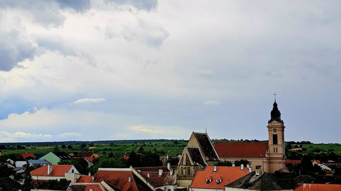 Viaggio culturale nel Burgenland – Opera e musical come fulcro del programma Vista di una città storica con tetti rossi sotto un cielo nuvoloso