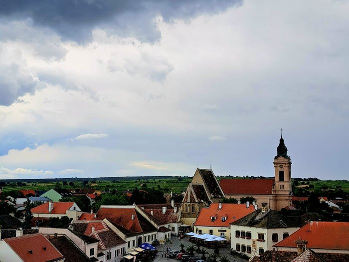 Viaggio culturale nel Burgenland – Opera e musical come fulcro del programma Vista di una città storica con tetti rossi sotto un cielo nuvoloso