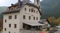 Neuauflage: Plattform Land startet 2. Sanierungsberatung für Private und Gemeinden Traditionelles Gasthaus Ostì Nicl vor bewaldetem Berg in ruhiger Landschaft