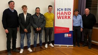 News Sechs Männer stehen neben einem Banner mit der Aufschrift Ich bin Handwerk.