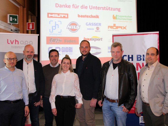 Imprese movimento terra: Michael Hofer confermato presidente Sette persone posano davanti a una parete con loghi degli sponsor a un evento