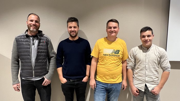 Piastrellisti: talento al centro dell’attenzione Quattro uomini sorridenti in abbigliamento casual davanti a un muro