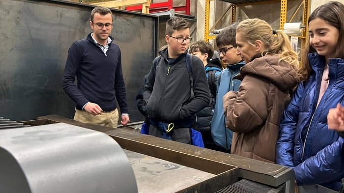 Bettenstopp verlängern – mit Maß und wirtschaftlicher Vernunft Gruppe von Schülern hört einem Lehrer in einer Werkstatt zu