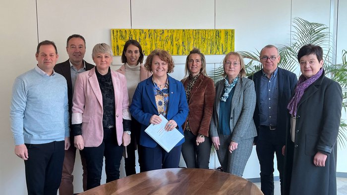 Antrittsbesuch der lvh-Spitze bei Landesrätin Rosmarie Pamer: Gemeinsam für eine starke Wirtschaft und zukunftsweisende Sozialpolitik Gruppe von neun Personen steht in einem Besprechungsraum vor einem ovalen Holztisch