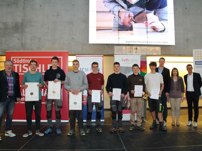 Jugendwettbewerb der Tischler/innen in der Berufsschule Bozen Junge Tischler mit Urkunden bei Jugendwettbewerb 2023 auf Bühne