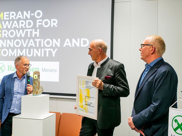 Jahreshauptversammlung des lvh gemeinsam mit dem hds Preisverleihung Meran-O Award mit drei Männern und Trophäe auf Podest