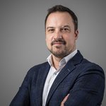 Das lvh-Team Porträt eines Mannes mit Bart, blauem Sakko und weißem Hemd vor grauem Hintergrund