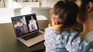 News Frau mit Kind nimmt an Videoanruf mit vier Personen auf Laptop teil