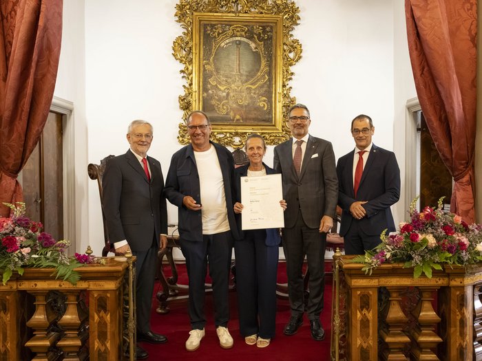 Premio Economia 2026: premiate 8 aziende associate lvh.apa Cinque persone in abiti formali in una stanza con tende rosse e fiori