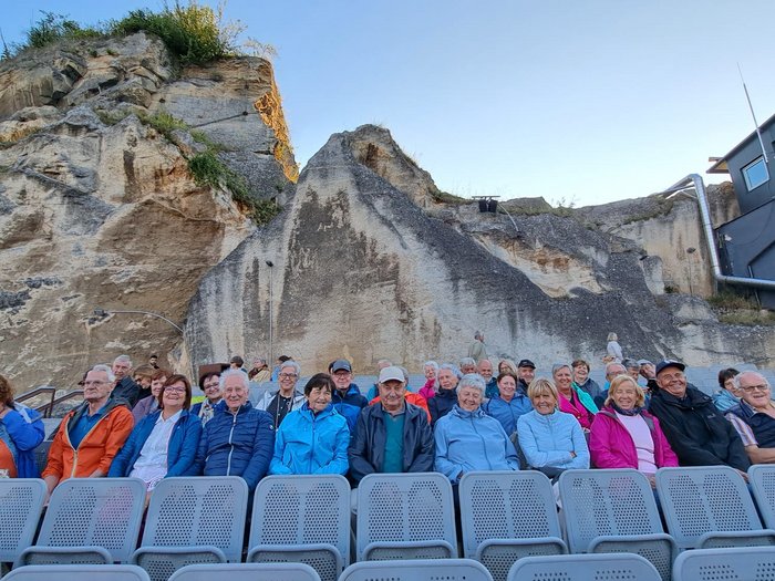 Viaggio culturale nel Burgenland – Opera e musical come fulcro del programma Anziani seduti su file di sedie davanti a una parete rocciosa in teatro all'aperto