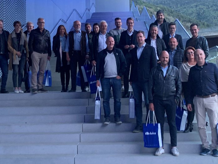 Blick nach vorne Gruppe von Erwachsenen steht auf einer Treppe mit blauen Duka-Tüten