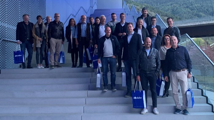 Blick nach vorne Gruppe von Erwachsenen steht auf einer Treppe mit blauen Duka-Tüten