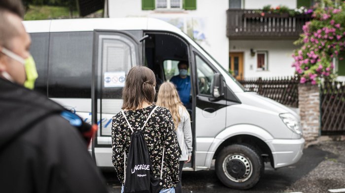 15 Mietwagenunternehmer unterstützen jetzt die SASA Menschen mit Masken warten, um in einen weißen Kleinbus einzusteigen