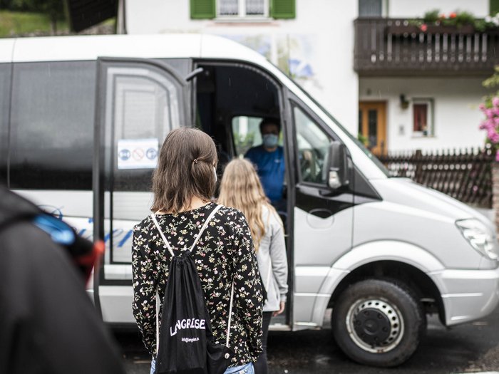 15 Mietwagenunternehmer unterstützen jetzt die SASA Menschen mit Masken warten, um in einen weißen Kleinbus einzusteigen