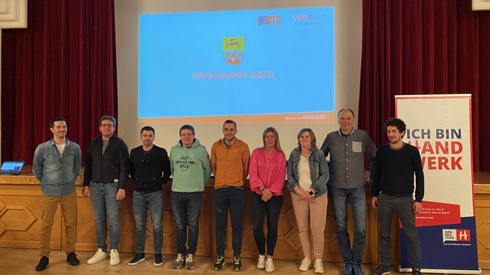 ABTEI – Bei der jüngsten lvh-Ortsversammlung in Abtei wurde ein neuer Ortsausschuss gewählt sowie wichtige Themen für das Handwerk angesprochen Gruppe von neun Personen vor Bildschirm mit Ortgruppe Abtei Präsentation