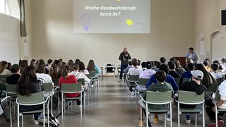 News Vortrag über Handwerksberufe mit Publikum in einem Saal