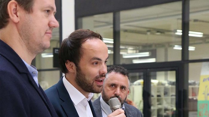 „Die beste Wirtschaftsförderung wäre, wieder arbeiten zu können…“ Drei Männer sprechen bei einer Veranstaltung, einer hält ein Mikrofon