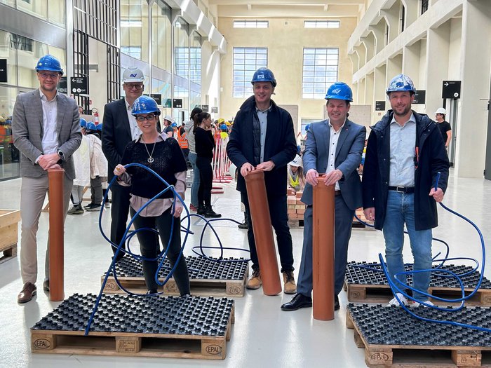 Vivere una giornata in cantiere Sei persone con caschi protettivi presentano materiali da costruzione in un capannone