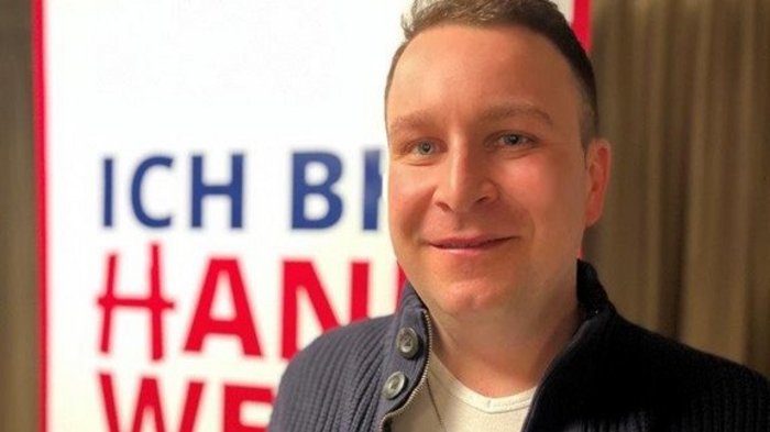 Zahlreiche Projekte in Villanders Mann steht vor einem Schild mit Text in deutscher Sprache