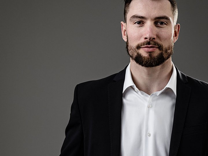 Dolomit Stone Ritratto di un giovane uomo in abito nero su sfondo grigio