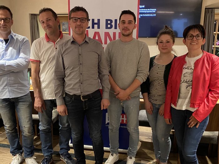 Stabübergabe im Handwerk in Klausen Sechs Personen stehen in einem Raum mit Tischen und Stühlen