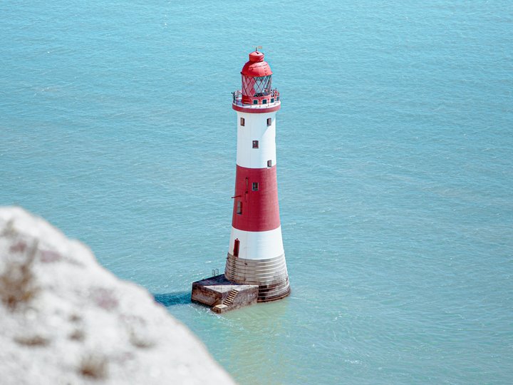 Digitale Lösungen Roter und weißer Leuchtturm im blauen Meer