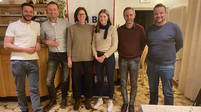 Dieter Happcher riconfermato presidente a San Candido Sei persone sorridenti in piedi davanti a un banner in una stanza