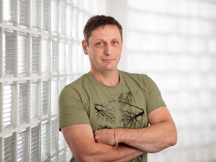 Mathias Piazzi als lvh-Bezirksobmann bestätigt Mann mit grüner T-Shirt steht vor eine Glaswand mit verschränkten Armen