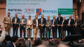 News Personen bei einer Banddurchschneidung vor einer Dankesleinwand mit Sponsorenlogos