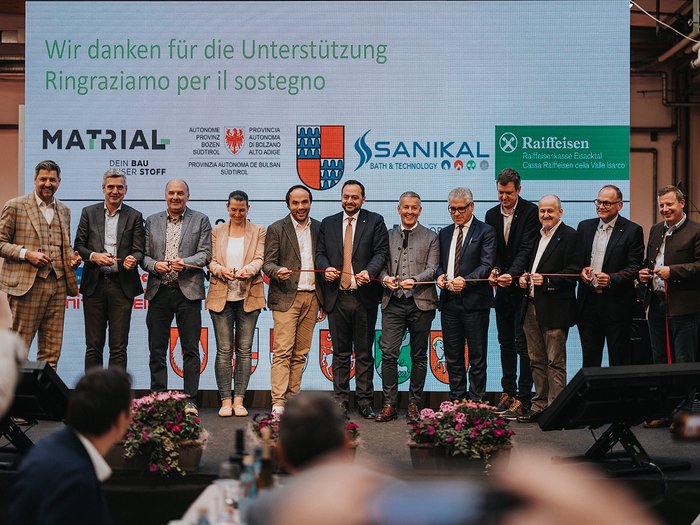 Erfolgreiche Eröffnung der Eisacktaler Wirtschaftsschau in Brixen – Ein Schaufenster der lokalen Wirtschaftskraft Personen bei einer Banddurchschneidung vor einer Dankesleinwand mit Sponsorenlogos