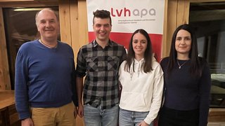 News Vier Personen stehen vor einem lvhapa-Banner in einem Holzraum