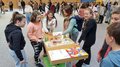 Schulprojekt "Clever gebaut": Selbst entwickelte Spiele prämiert Kinder und Lehrerinnen zeigen ein Holzmodell bei einem Schulprojekt in der Turnhalle