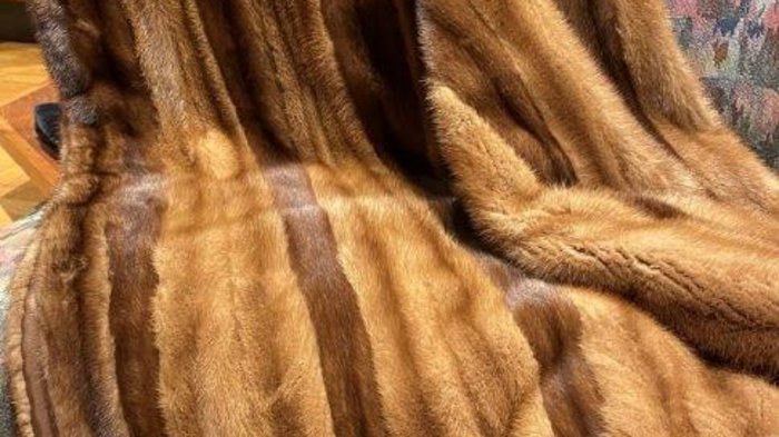 Pellicciai Coperta di pelliccia marrone appoggiata su poltrona