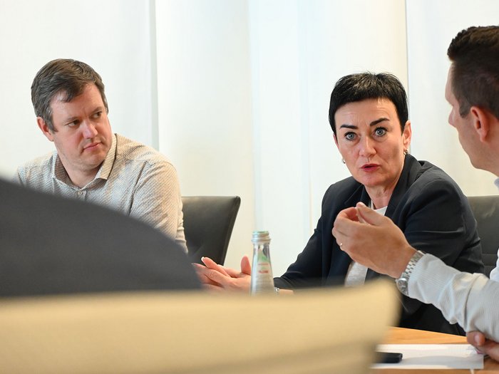 Abitare deve essere accessibile! Sfide e soluzioni in Alto Adige Tre persone impegnate in una discussione animata in ufficio