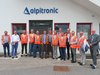 Home Gruppo di uomini con giubbotti di sicurezza davanti all'edificio Alpitronic